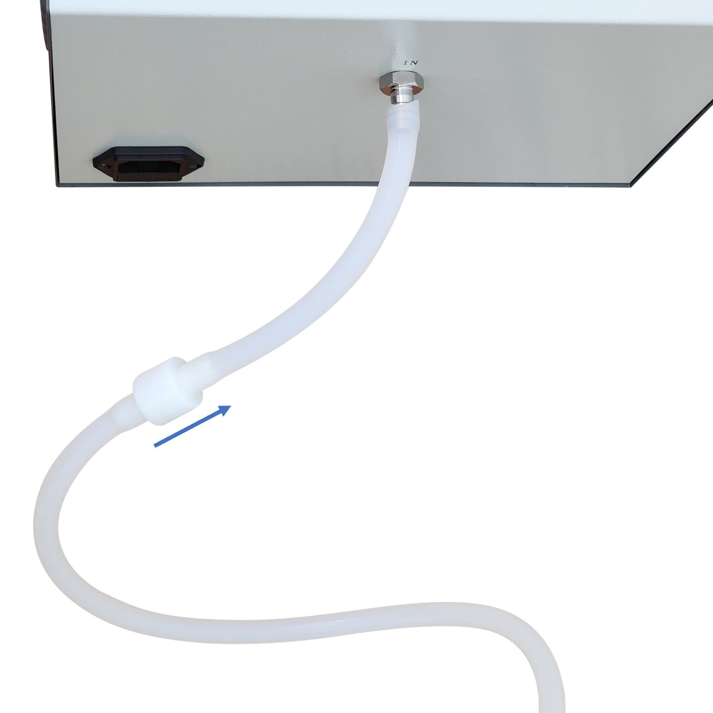 Close-up of vacuum pump's "IN" port with clear tubing attached, showing an arrow indicating flow direction.