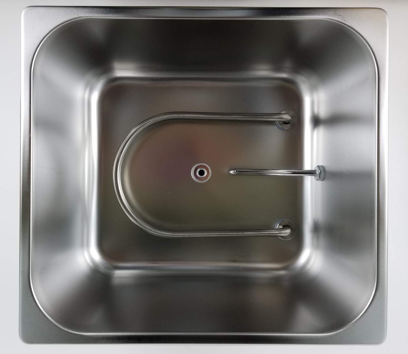 Top-down view of a stainless steel water bath interior showing the U-shaped heating element and temperature sensor.