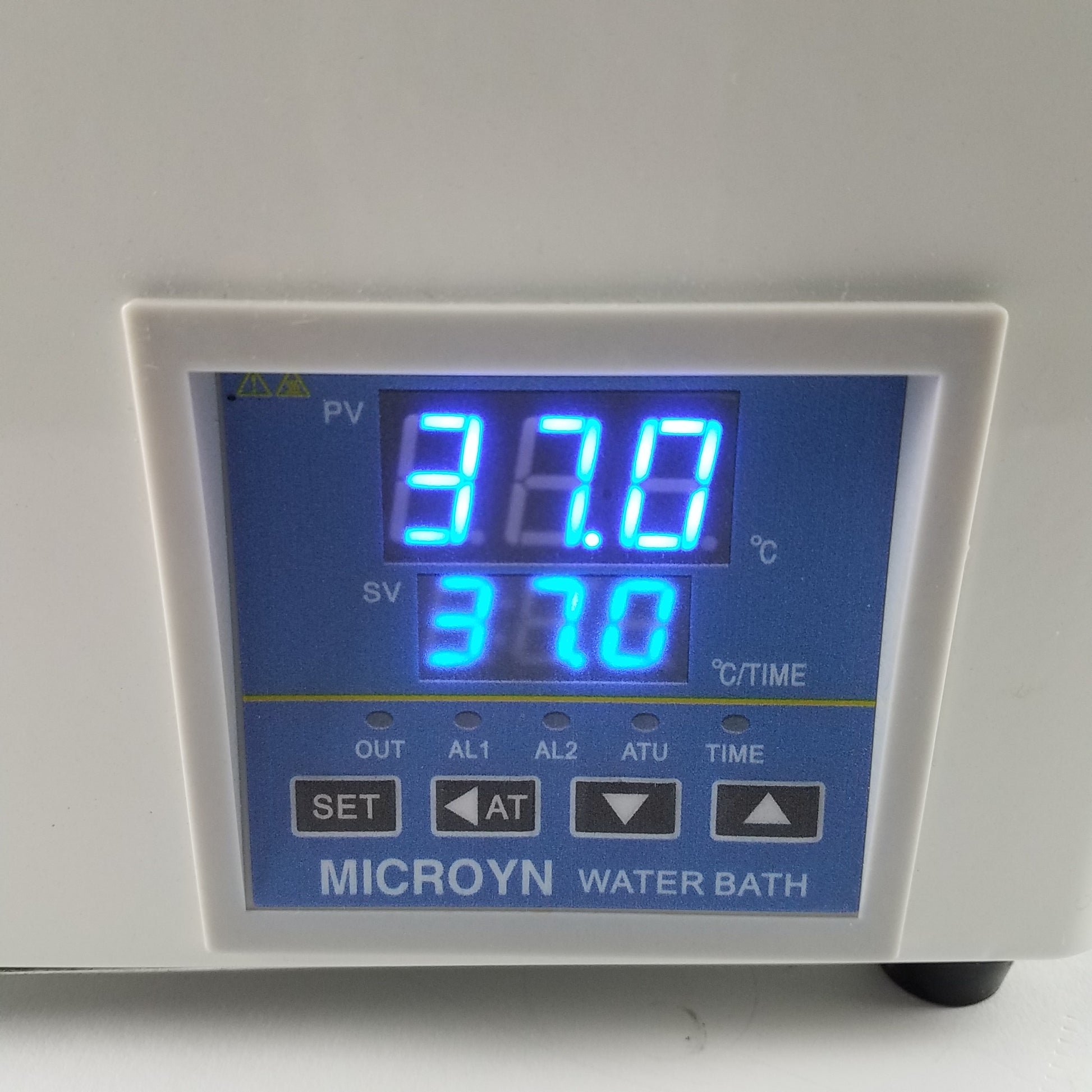 Close-up of a MICROYN water bath digital control panel displaying "37.0" for both PV and SV, with control buttons below.